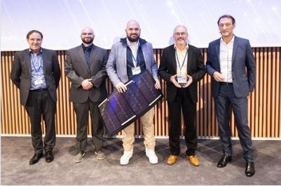 五名男子拿着一个奖项和一块小型太阳能电池板摆姿势合影.